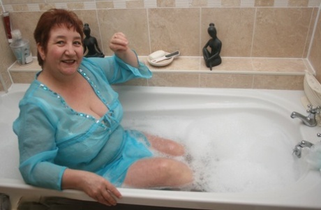 As she rests in a tub, redhead singer Kinky Carol is fully clothed and looks like she's on a diet.