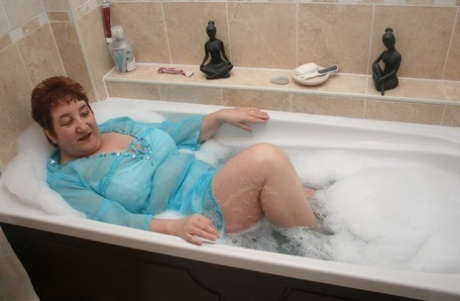 Redhead Nan Kinky Carol Parks Her Fat Figure In A Tub While Fully Clothed