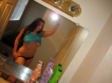 Amateur solo girl captures images of her large breasts in a bathroom mirror.