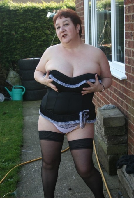 Large tits are unleashed by BBW Kinky Carol, an older amateur, outside her residence.