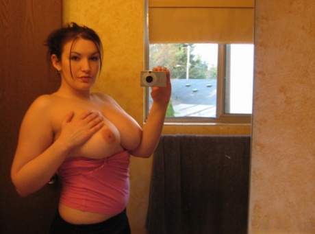 Uncommon girl captures her oversized breasts in a mirror while taking selfies.