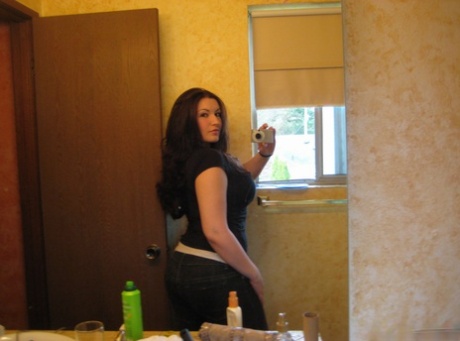 Self-sewn action in a bathroom mirror involves a curvy brunette amateur.