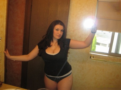 In a bathroom, an amateur hairsty is seen performing topless self-shots. The curvy brunettes look great in pictures.