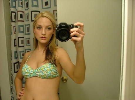 Blonde teen Marilyn takes mirror selfies while wearing a three-piece swimsuit