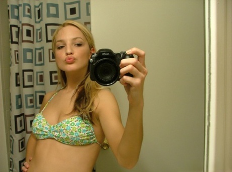 Blonde teen Marilyn takes mirror selfies while wearing a three-piece swimsuit