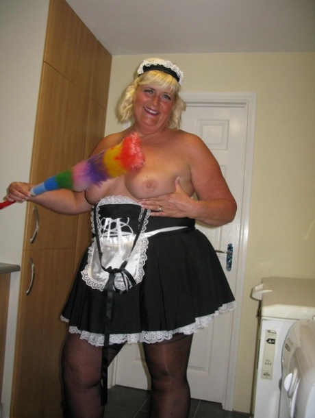 While in a kitchen as she gets dressed, Chrissy Uk, an overweight blonde maid, exposes herself.