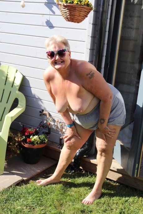 At home in the backyard, fat Nan Valgasmic Exposed can be seen playing with her breasts without any shoes on.