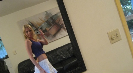 While taking mirror selfies, a blonde amateur exposes her buttocks while naked.