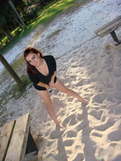 Redheaded amateur Evie shows her underwear while barefoot on a patch of sand