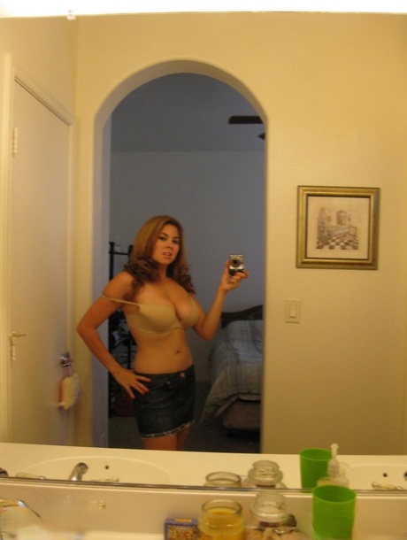 Using her bathroom mirror, Busty Mai takes pictures of her enormous real tits.