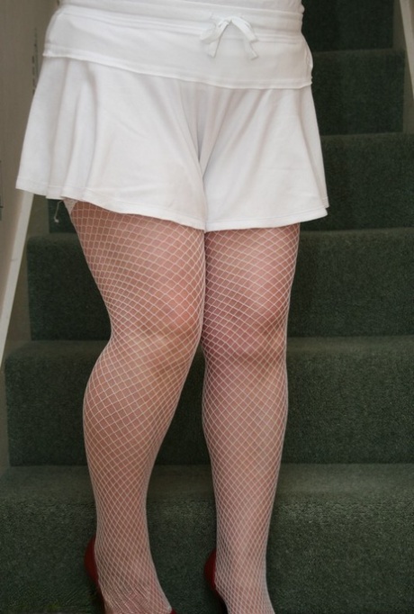 As she shows off her fishnet hosiery and bra, Kinky Carol, a mature redhead, goes for a stroll through the closet.