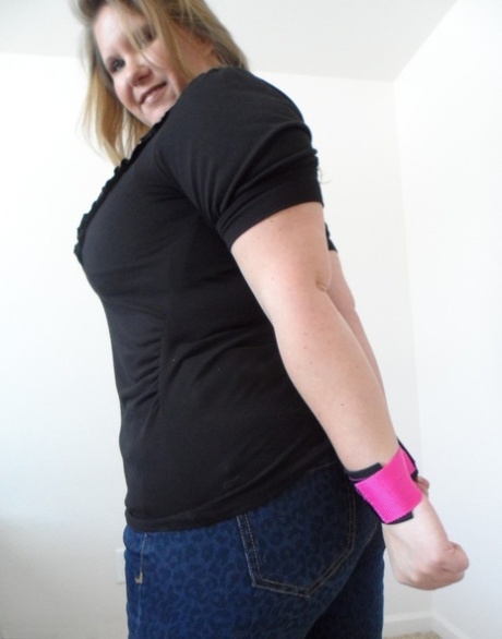 Busty Kris Ann, a tall woman of short heights, displays her enhanced pants while wearing handcuffs.