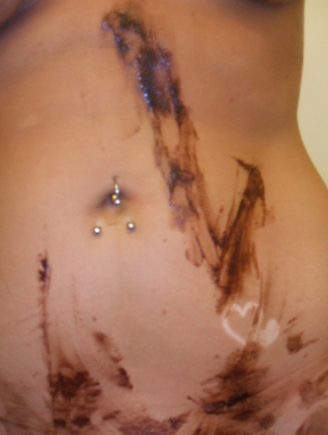 Chocolate sauce is used to cover the naked body of a blonde girl with her beautiful eyes.