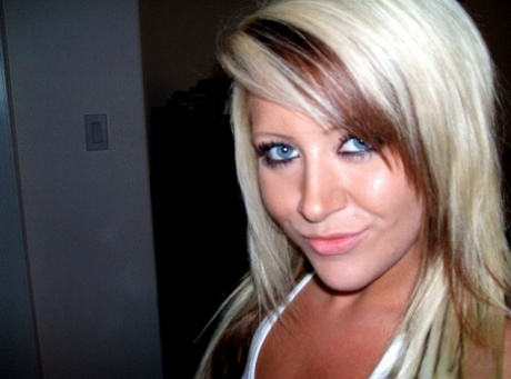 A blonde amateur with blue eyes takes selfies in a comical and endearing style.