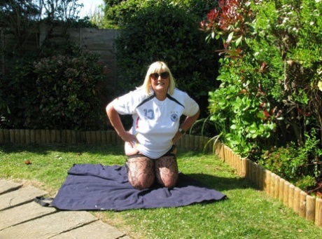 Nylons and revealing clothing are worn by Chrissy Uk, a mature woman who is blonde and fatty, in her backyard.