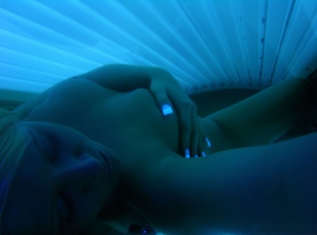 Blonde teen takes naked selfies during a session at the tanning salon