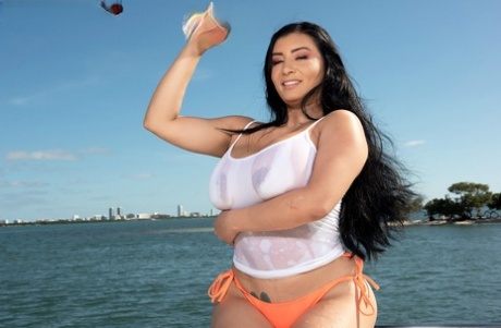 During boating, Selena Adams releases her large breasts from an over-sized shirt on the water.