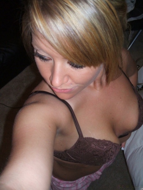 An amateur in blonde clothing, wearing a brassiere and pyjamak bottoms, captures self-shots.