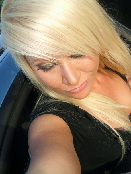 Taking daring selfies while in a car, the beautiful blonde girl looks at her friends and family.