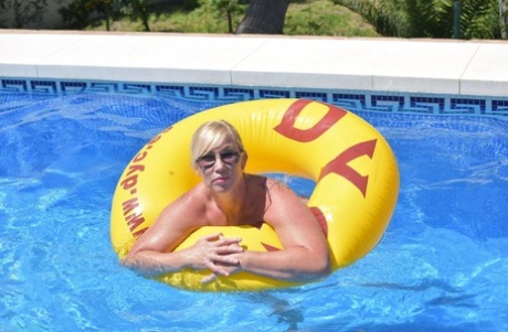 In a swimming pool, the amateur blonde Melody shows off her plump physique.