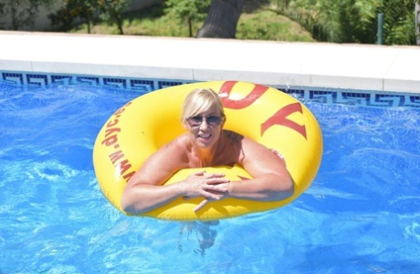 An amateur blonde named Melody exhibits her plump physique while swimming in a pool.