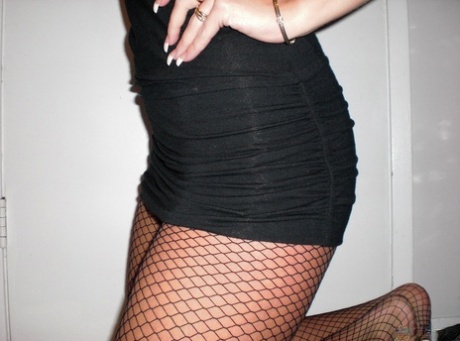 Teen amateur takes self shots while removing a little black dress in mesh hose