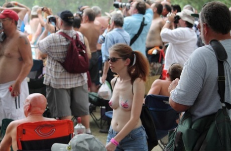 Amateur girls and strippers get naked on an outdoor stage at an adult event