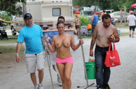 On an outdoor platform, strippers and amateur girls nude during a popular adult gathering.