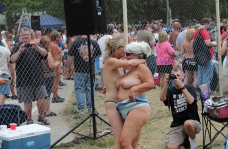 An outdoor stage at an adult event features naked amateur girls and strippers.