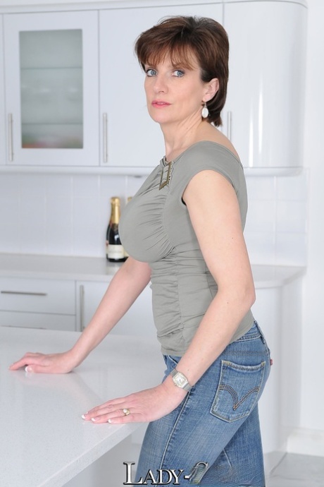 Зрелая жена Леди Соня щеголяет большими сиськами без лифчика в футболке на кухне