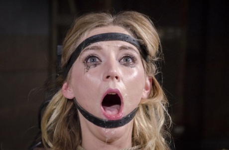While being restrained, Mona Wales, a female, has her face fucked while being impaled on a Sybian man.