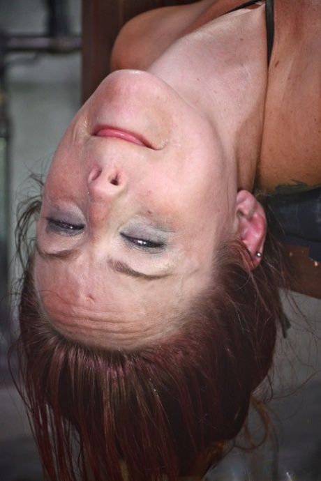 Restrained: Young redhead Bella Rossi is left completely humiliated while being clung to a rack.