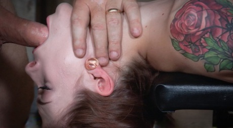 On a bondage table, Anna De Ville has her throat fucked by the tattooed woman.