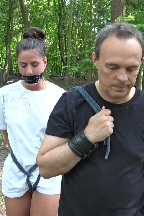 A young brunette slave is disciplined and indulged by her Master in the woods.