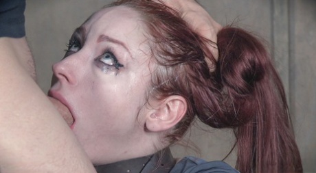 Violet Monroe, a redhead sex slave, is made to perform a deep-throated sexual act.