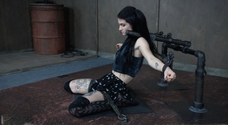 In a hidden dungeon, Lydia Black, a young girl with dark hair, is subjected to facial abuse and restrained in confinement.