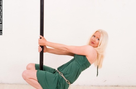Natural blonde is fastened with a ballgag attached to black rope.