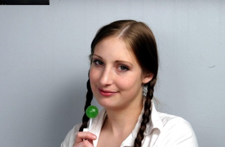 Schoolgirl with braided pigtails licks a sucker after escaping rope bonds