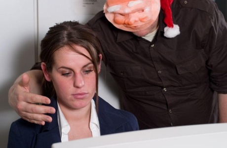 Stunteous man wears a Santa mask ball and tie up an undressed brunette in the background.