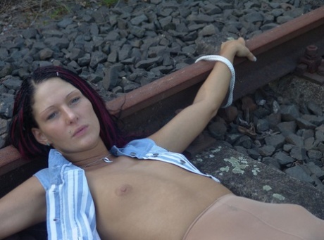 An amateur model can be seen being pulled along railway tracks with her pantyhose in place.