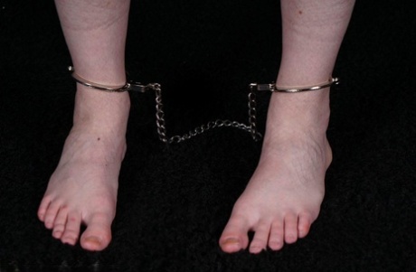 Clothed woman watches as time goes by while tied up and chained.