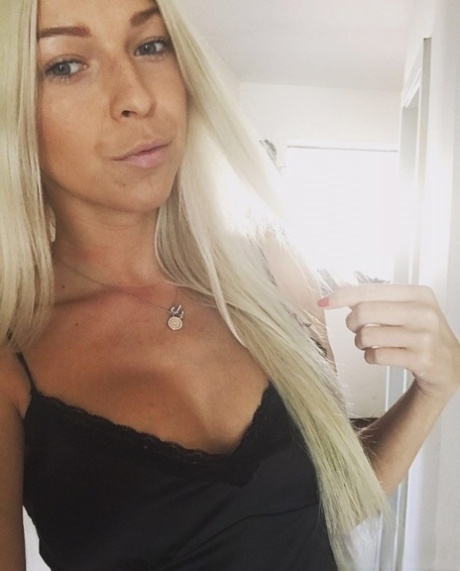 An amateur blonde from Slovenia poses for some selfies while working.