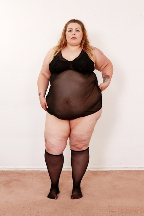 A super-sized BBW Baby Doll is seen naked on a futon in the knee-high nylons.