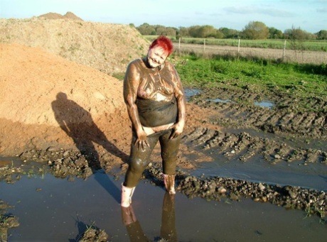 Mature redhead Valgasmic Exposed covers her fat body in mud