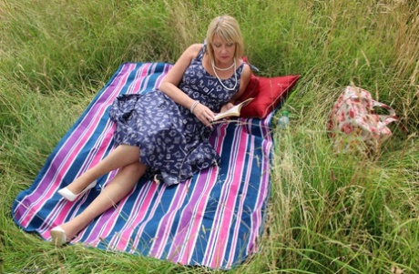Older UK is thrown doggystyle on a blanket in the middle of a hay field.
