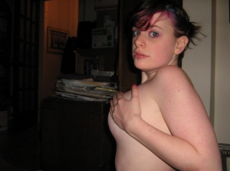 The act of taking nude selfies involves a young amateur with short red hair and SFW vibe.