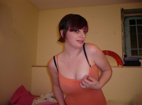 Redheaded amateur teases on her bed while wearing striped underwear