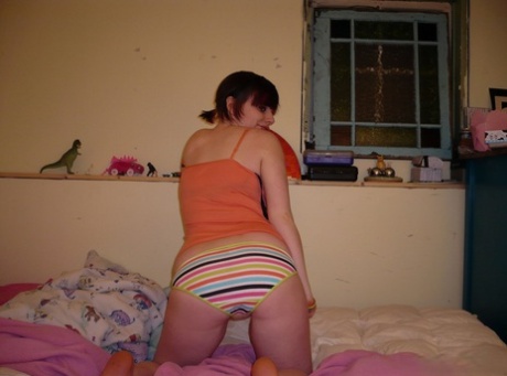 Redheaded amateur teases on her bed while wearing striped underwear