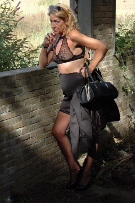 Kyras Nyras, who is still blonde, models her stiletto heels with hosiery and a black skirt.