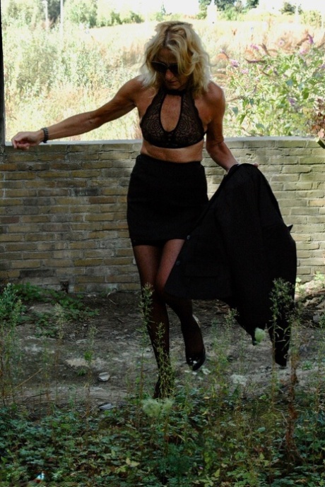 Aged 28-year-old Kyras Nylons wears a black skirt and high heels with hosiery.